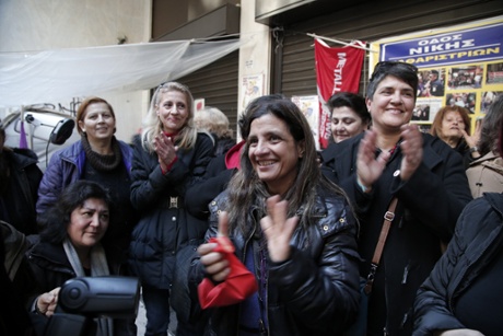 Finance Ministry's laid-off cleaning women react as they watch on television the new Greek Finance Minister Yanis Varoufakis' announcing that the government will re-hire them in the public sector, in Athens, on Wednesday, Jan. 28, 2015.