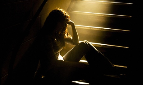 Depressed girl in stairwell with light streaming in