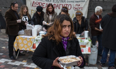A woman takes away a portion of food from a soup kitchen in Athens.