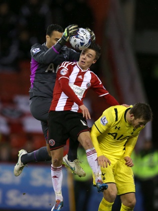 Tottenham Hotspur goalkeeper Michel Vorm claims the ball off the head of Sheffield United's Steven Scougall.