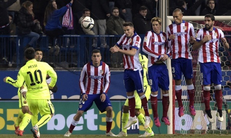 Lionel Messi curls a free-kick over the wall but the Atletico keeper Jan Oblak is more than equal to it.