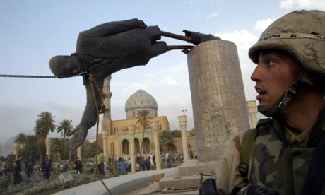 A U.S. soldier watches as a statue of Iraq's President Saddam Hussein falls in central Baghdad in April 2003.