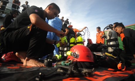 Indonesian navy divers prepare their equipment as the search for the wreckage of the AirAsia jet continues