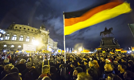 Participants hold German national flags during a demonstration by anti-immigration group Pegida outs
