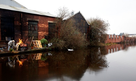 A man burns rubbish at a canal-side factory at Attercliffe in the Lower Don Valley.