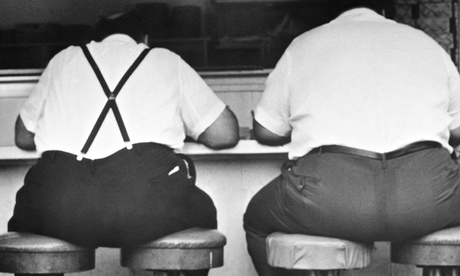 Two obese men sitting on four stools Men in a Diner