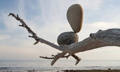 balanced stones on a fallen tree on a beach