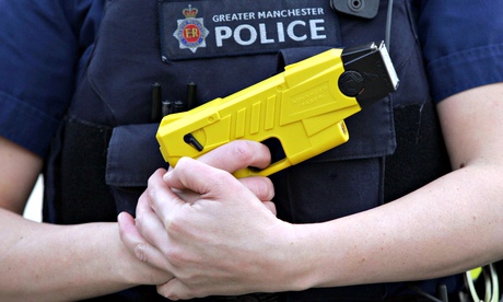 A Greater Manchester police officer holds a Taser stun gun