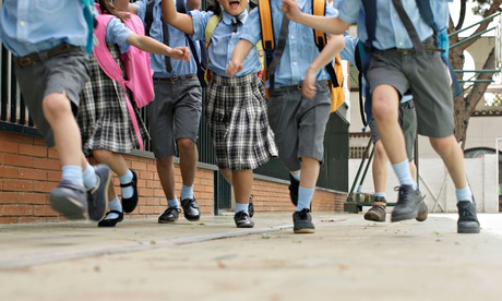 Schoolchildren running down a street
