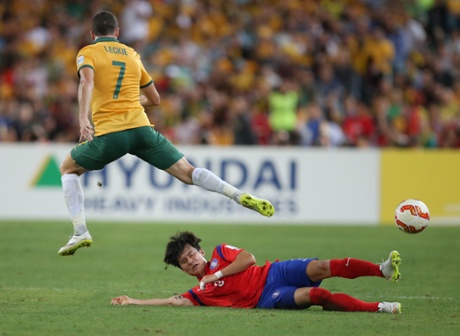 South Korea's Kim Jin-Su slides in to tackle Mathew Leckie.
