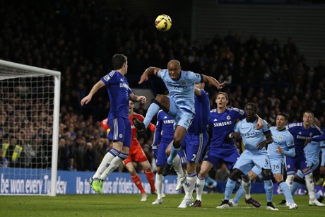 Vincent Kompany tries to head the ball in the Chelsea penalty area.