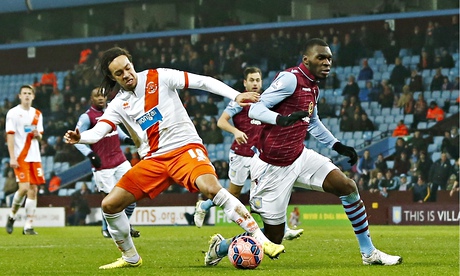 Aston Villa's Christian Benteke goes to ground after a challenge from Blackpool's Charles Dunne
