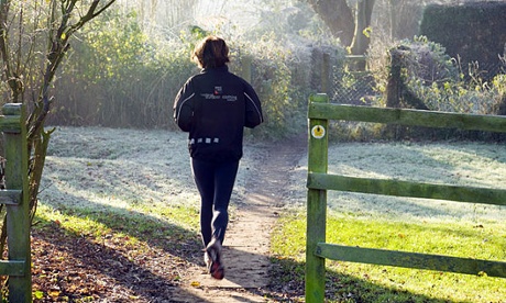 Woman jogging on the Thames Path on a frosty morning