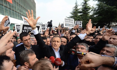 Ekrem Dumanli, editor-in-chief of Zaman newspapers, is surrounded by a sea of supporters as he is arrested. 