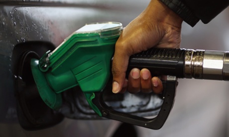 A driver fills their car with petrol at a filling station on December 17, 2014 in London, England.