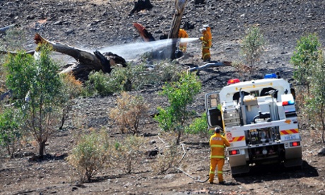 Firefighters put out spot fires near the One Tree Hill area as fires burn through the Adelaide Hills.