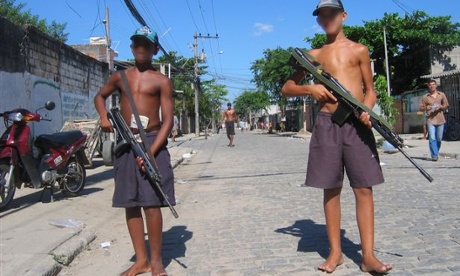 Armed bandidos, with pixelled faces, stand guard in Vila Aliança.
