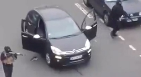 An image from a video circulating on Facebook and YouTube, showing two gunmen on a road near the offices