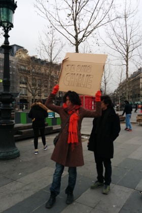 A woman stands in solidarity with those killed in Paris shooting.