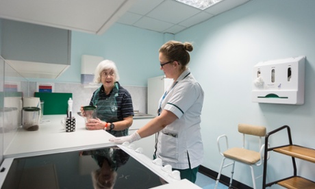 Occupational therapist Amy Hemus helps Angela Rankin, 68, who suffered a stroke a week ago, in a purpose-built kitchen within Addenbrooke's hospital.