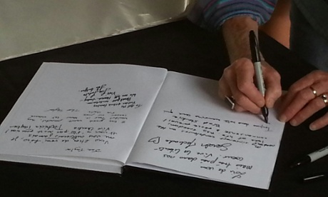 People sign a book of condolence in Melbourne where about 1000 people gathered at a vigil for the victims of the Charlie Hebdo attack.