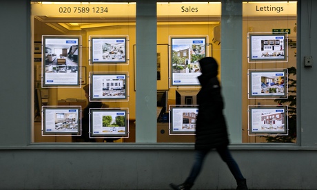 A pedestrian walks past an estate agents