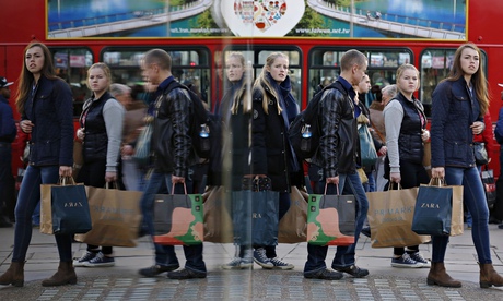 Shoppers are reflected in a window 