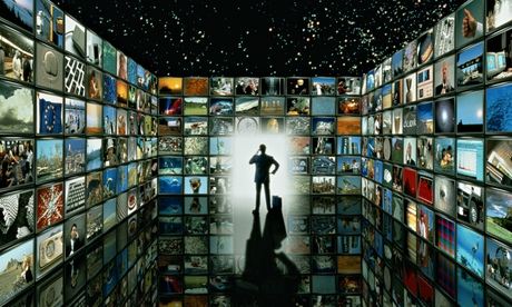 Man in a room filled by screens