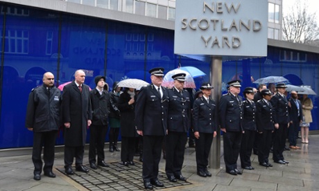British police officers observe a two-minute silence outside New Scotland Yard, London, in tribute to their French colleagues killed in the Paris attack.