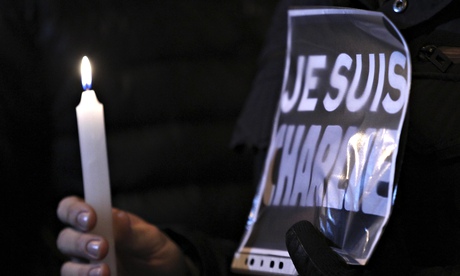 A woman holds a placard reading