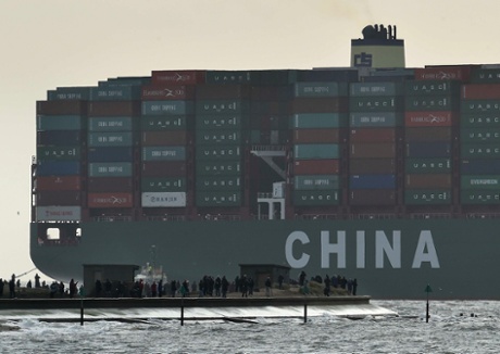 Onlookers watch from a harbour wall as the largest container ship in world, CSCL Globe, docks during its maiden voyage, at the port of Felixstowe in south east England, January 7, 2015.