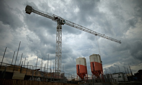 A crane operates as construction workers build retirement homes on a Northwich housing development