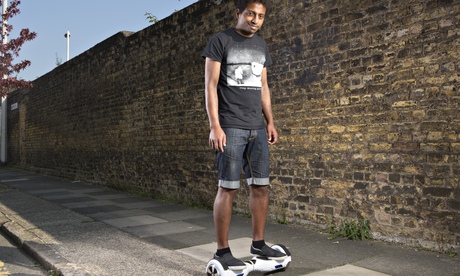 Jay standing on a Swegway wheeling device next to a brick wall
