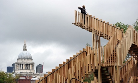 A woman photographs St Paul’s Cathedral in London from the top of the Endless Stair, an installation inspired by Escher’s surreal drawings of neverending staircases.