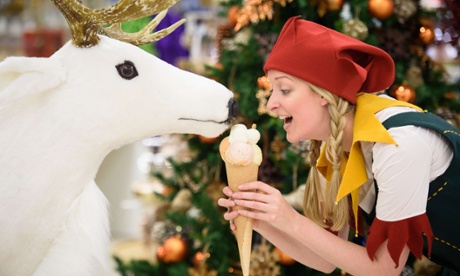 A Christmas elf poses with an ice cream and a toy reindeer during a promotional event to launch the Selfridges Christmas Shop in their flagship store in central London