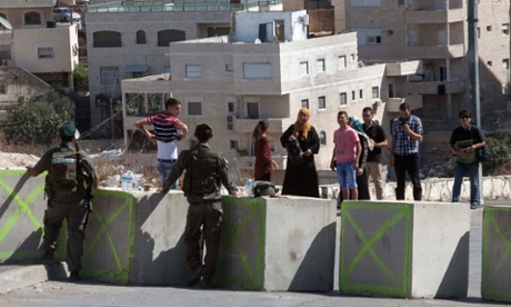 Palestinian residents of the east Jerusalem neighbourhood of Issawiya wait to pass an Israeli checkpoint on Friday, one of a number to have been set up around the city at the government's instruction.