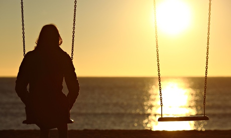 Woman watching sunset alone on a swing