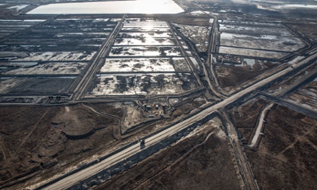 Trucks and machinery along routes within the Suncore Oil Sands site near to Fort McMurray in Northern Alberta. Canada's tar sands is one of the largest industrial projects on the planet, turning boreal forest, rivers and bogs into a scarred landscape.