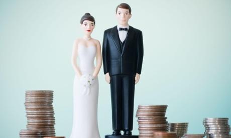 Wedding cake husband and wife surrounding by stacks of coins