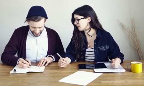 Couple writing at the deskI