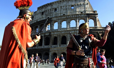 Men dressed as gladiators pose for tourists in front of the Colosseum in Rome