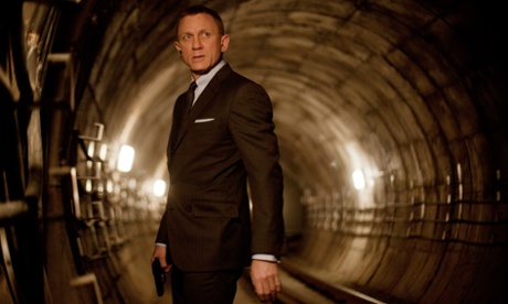 Daniel Craig dressed in a razor sharp lounge suit as James Bond, stands in a tunnel of the London Underground network