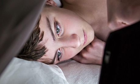 Teenage boy using a digital tablet at night.