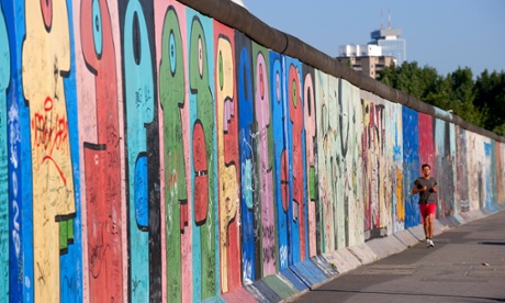 A jogger runs alongside the Berlin Wall in the Friedrichshain district, in east Berlin.