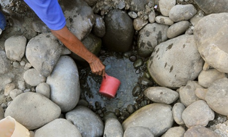 man collects water from pit
