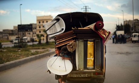 A Syrian boy holds a satellite antenna as he travels on the back of a truck in the northern Syrian city of Aleppo on April 15, 2013.
