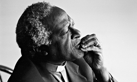 Desmond Tutu, in a three-quarters view, his hand resting on his mouth, eyebrows knitted