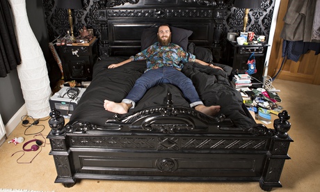 Ben spreadeagled on his black gothic-style double bed