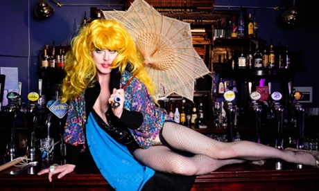 Co-founder of east London gay pub, The Glory, John Sizzle in drag costume lies along the pub bar.