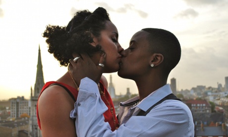 A publicity image for the feminist collective Club des Femmes of two women kissing, in the background is the London skyline.